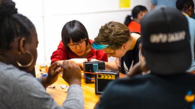 Group of people around table with small amplifiers on